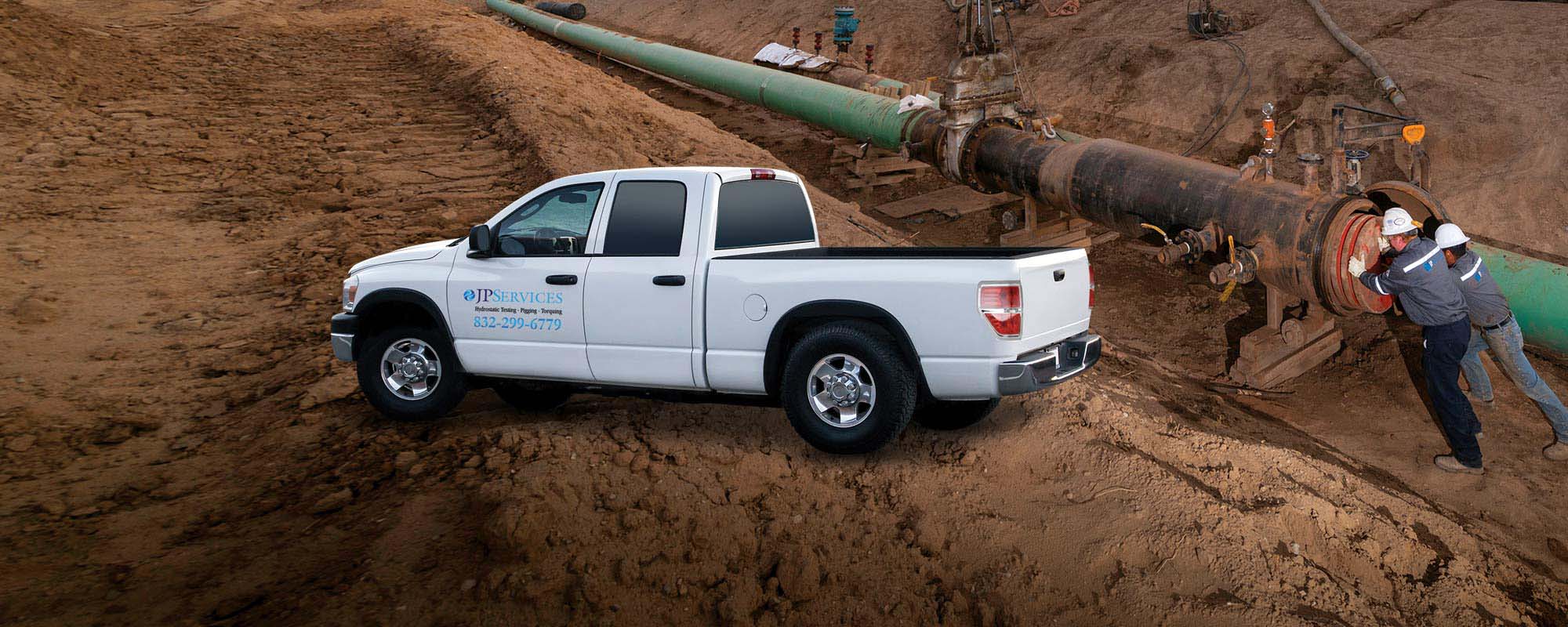 White pickup truck with JPServices logo on it parked beside pipeline 