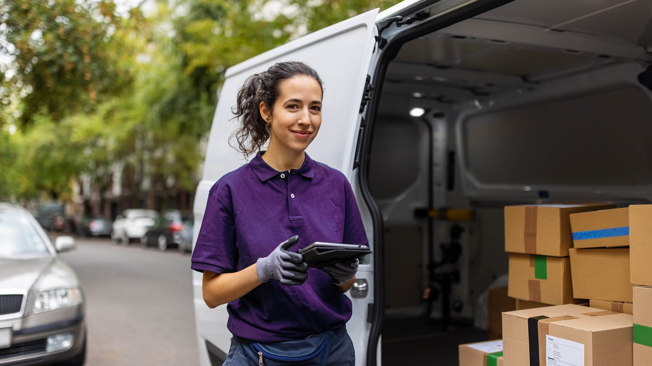 woman standing infront of van holding tablet