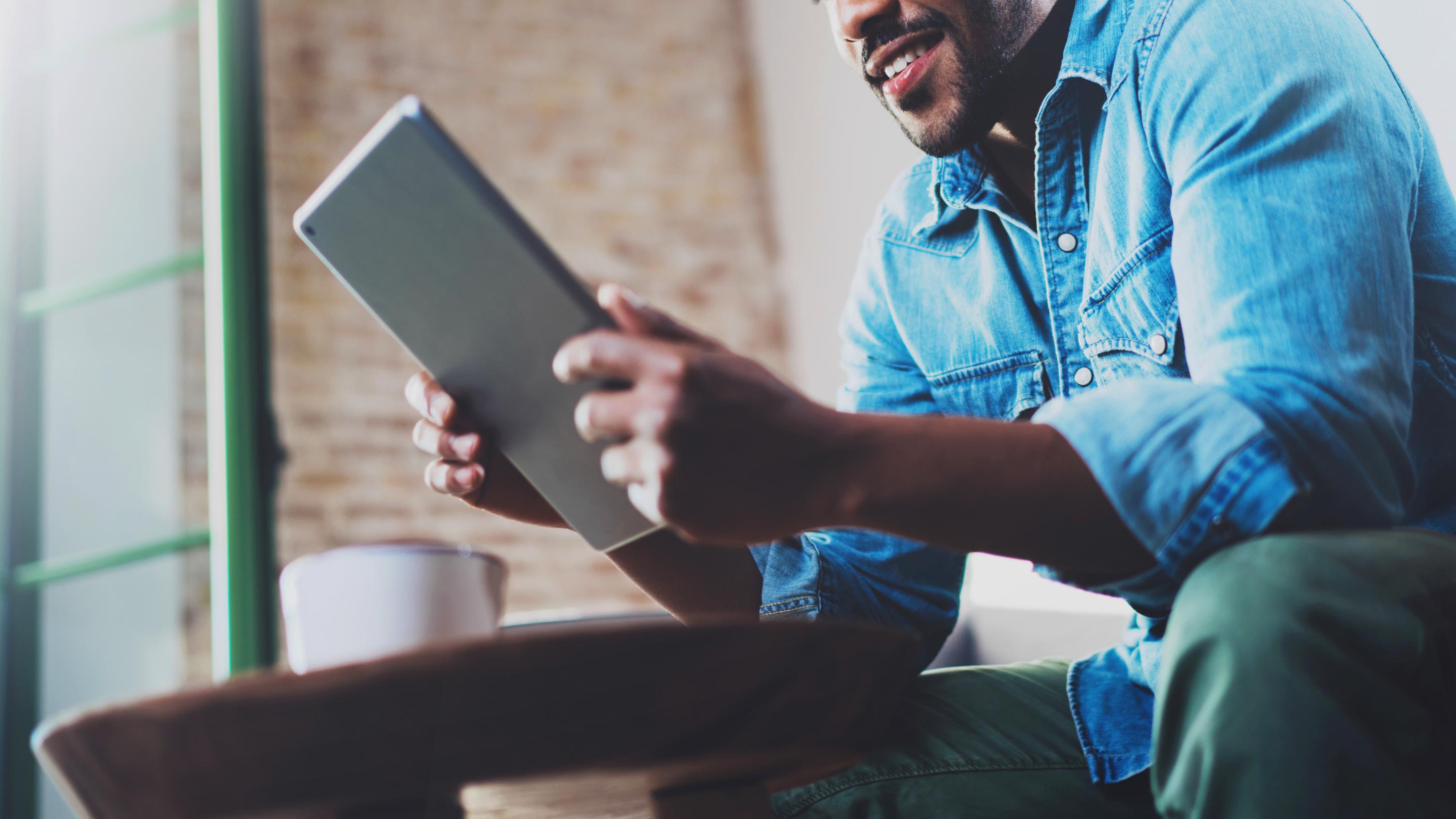 man sitting using tablet