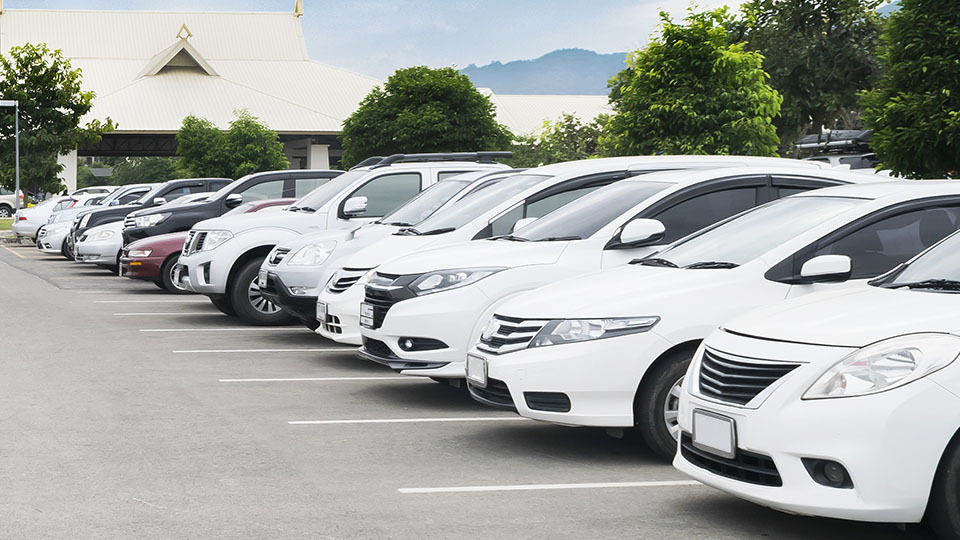 row of white cars in a parked in a lot