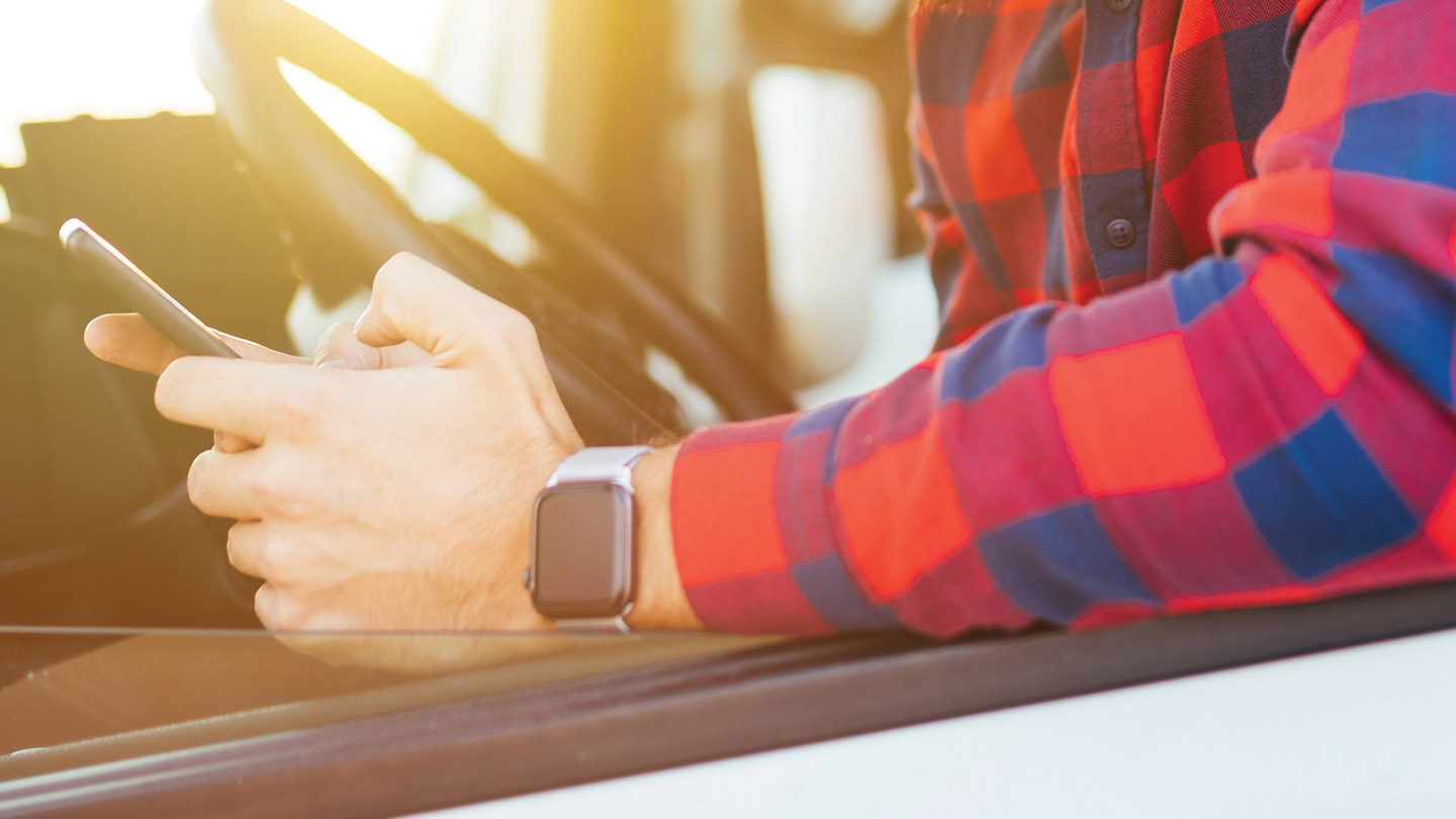 Person using phone in parked vehicle