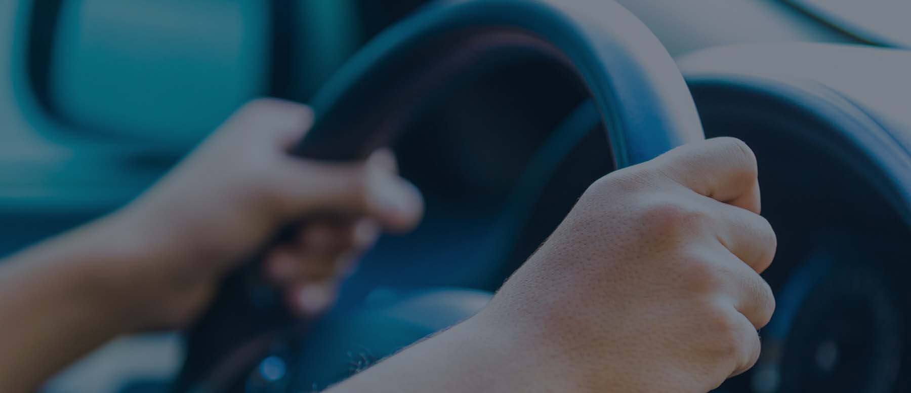 Driver's hands on a steering wheel 