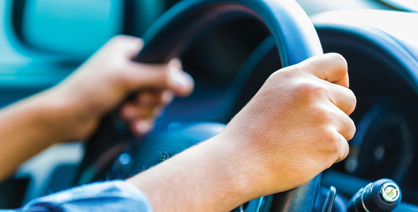 Driver's hands on a steering wheel 