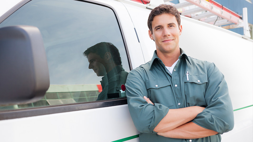 Field services employee standing outside of white van