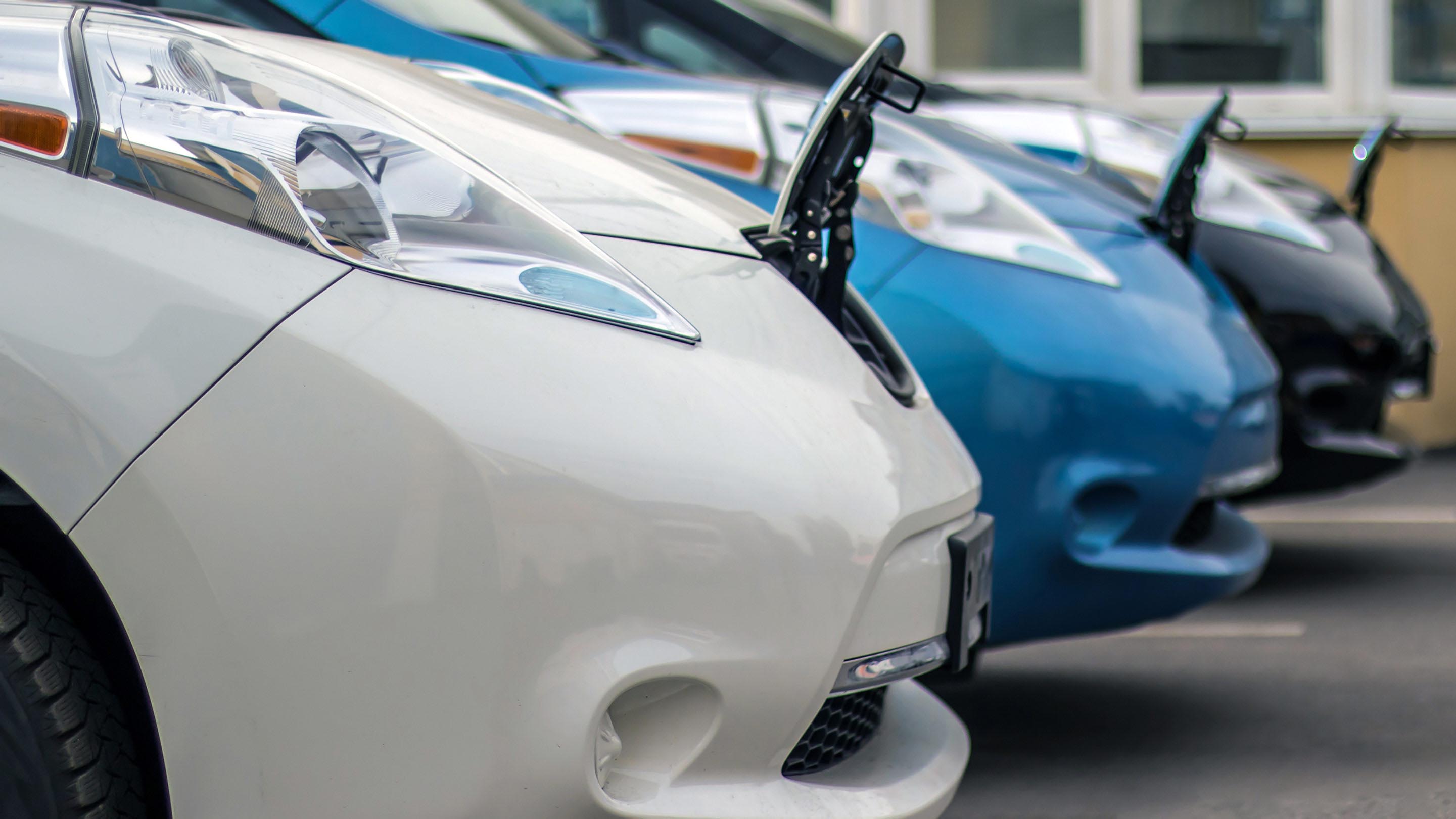 Three vehicles parked beside each other with front of car opened