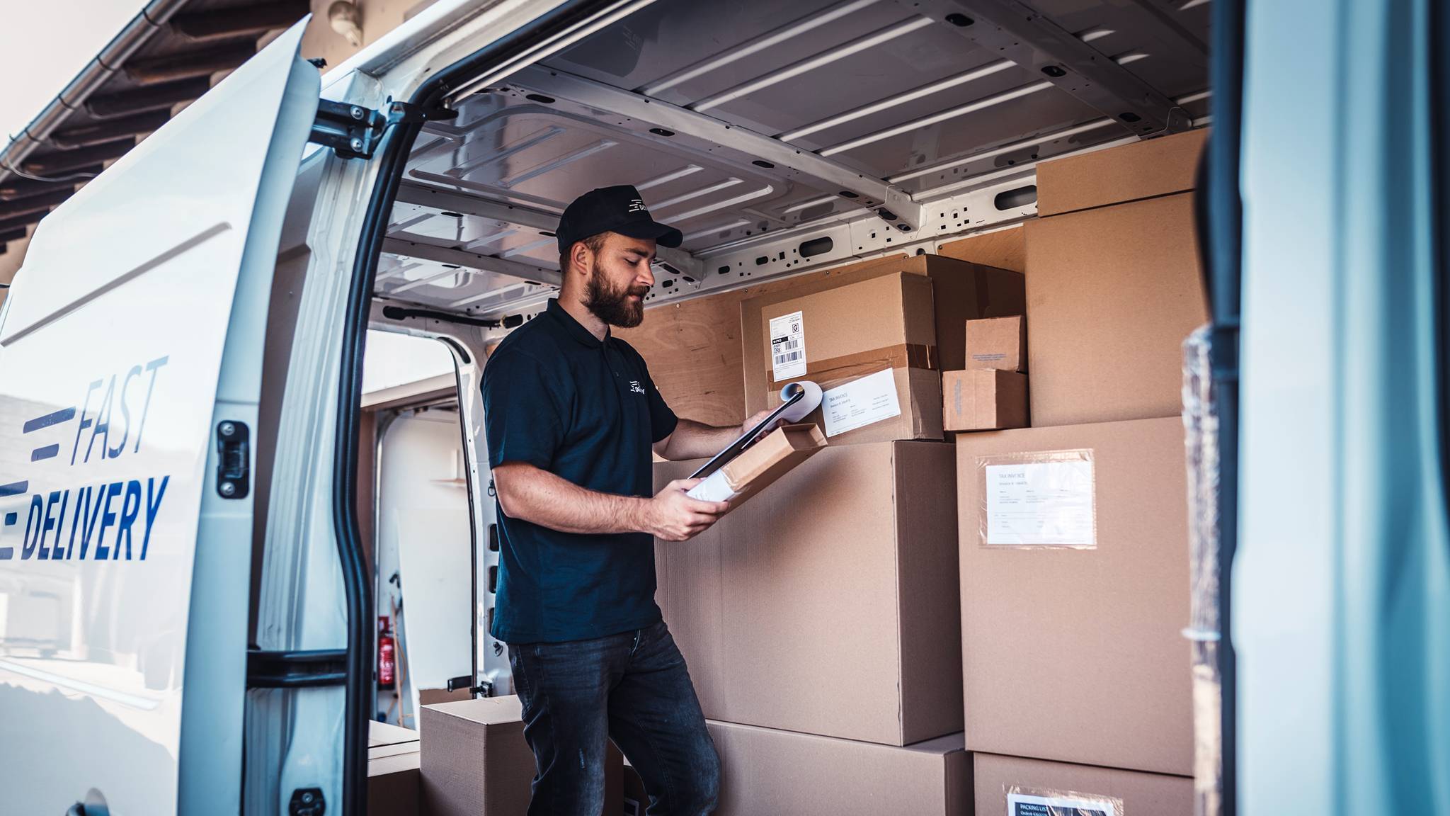 Delivery driver checking parcels inside a van