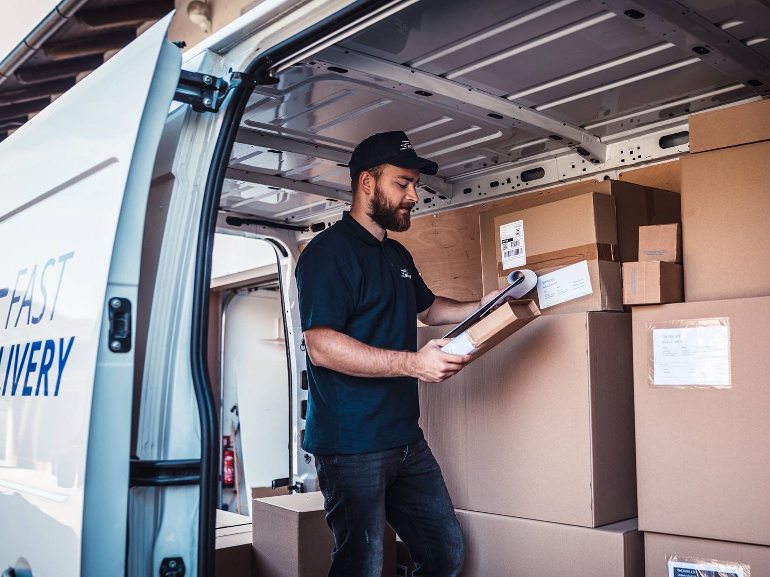 Delivery driver checking parcels inside a van
