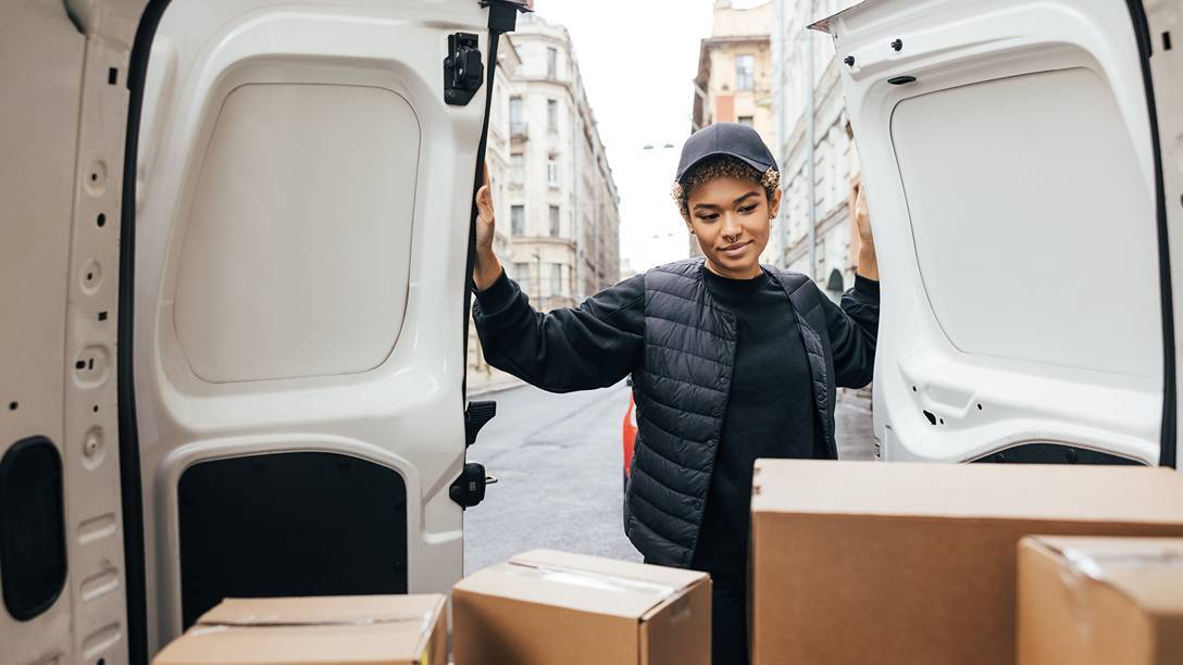 Courier opening van doors with parcels inside