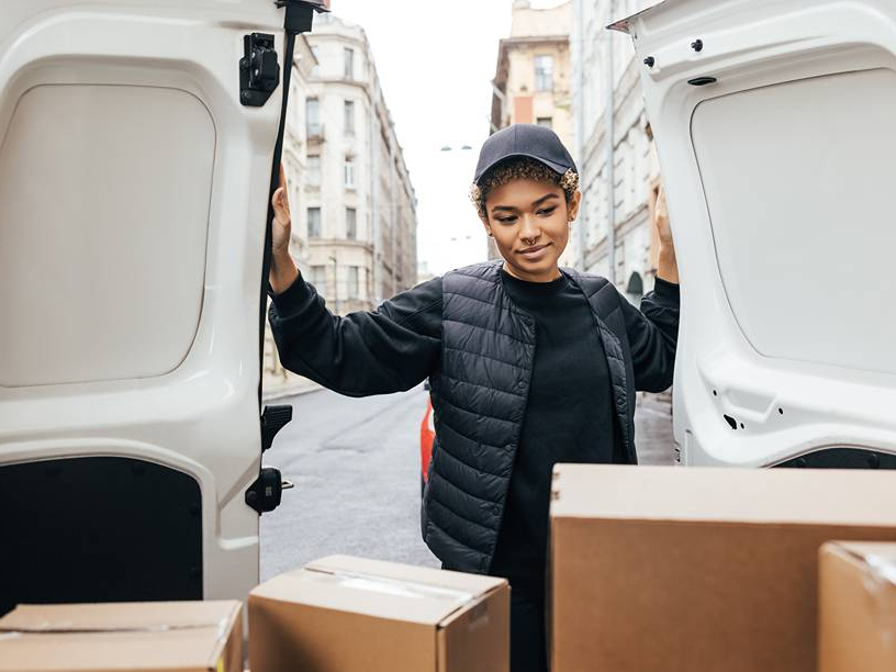 Courier opening van doors with parcels inside