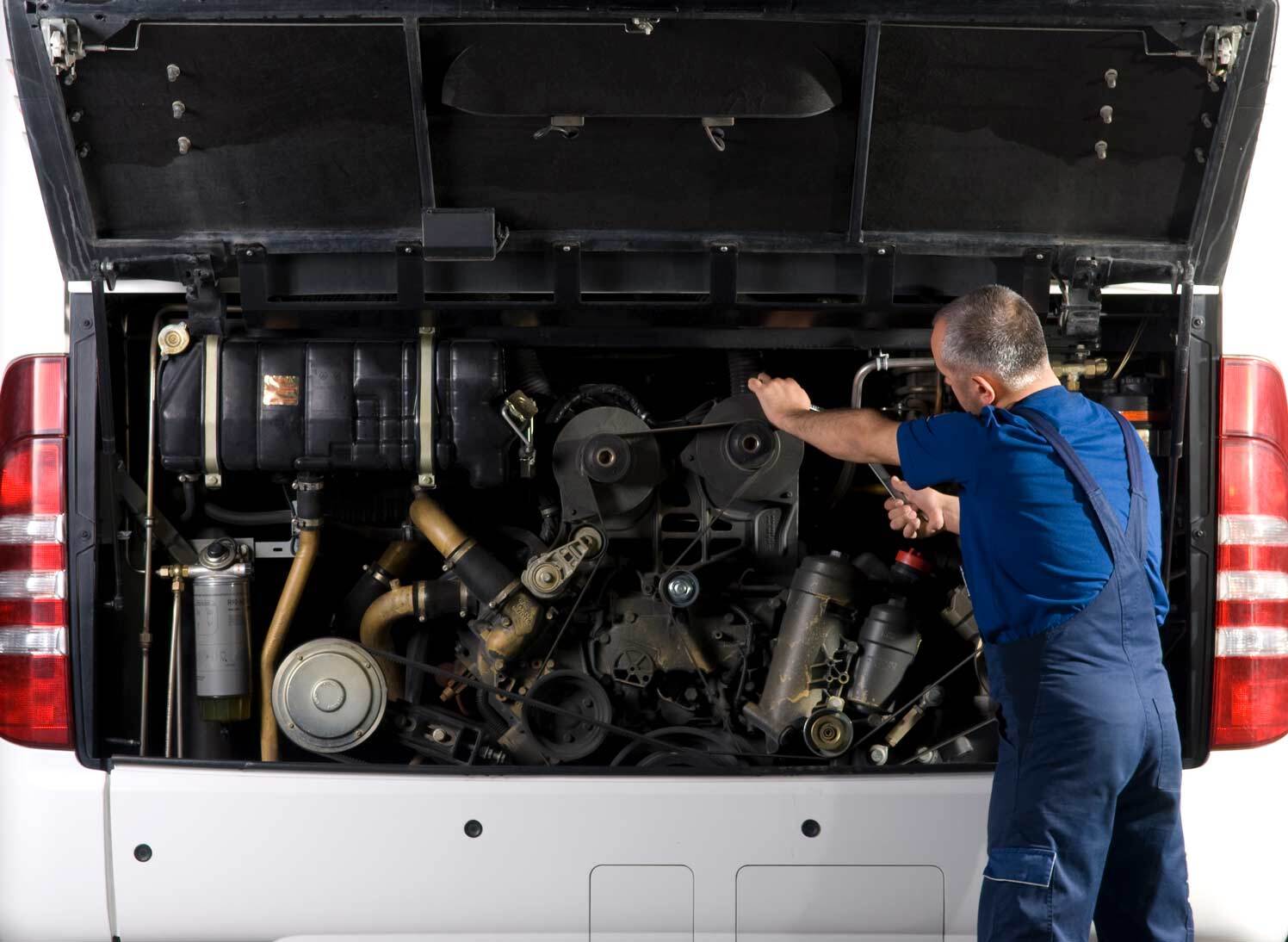 man repairing bus
