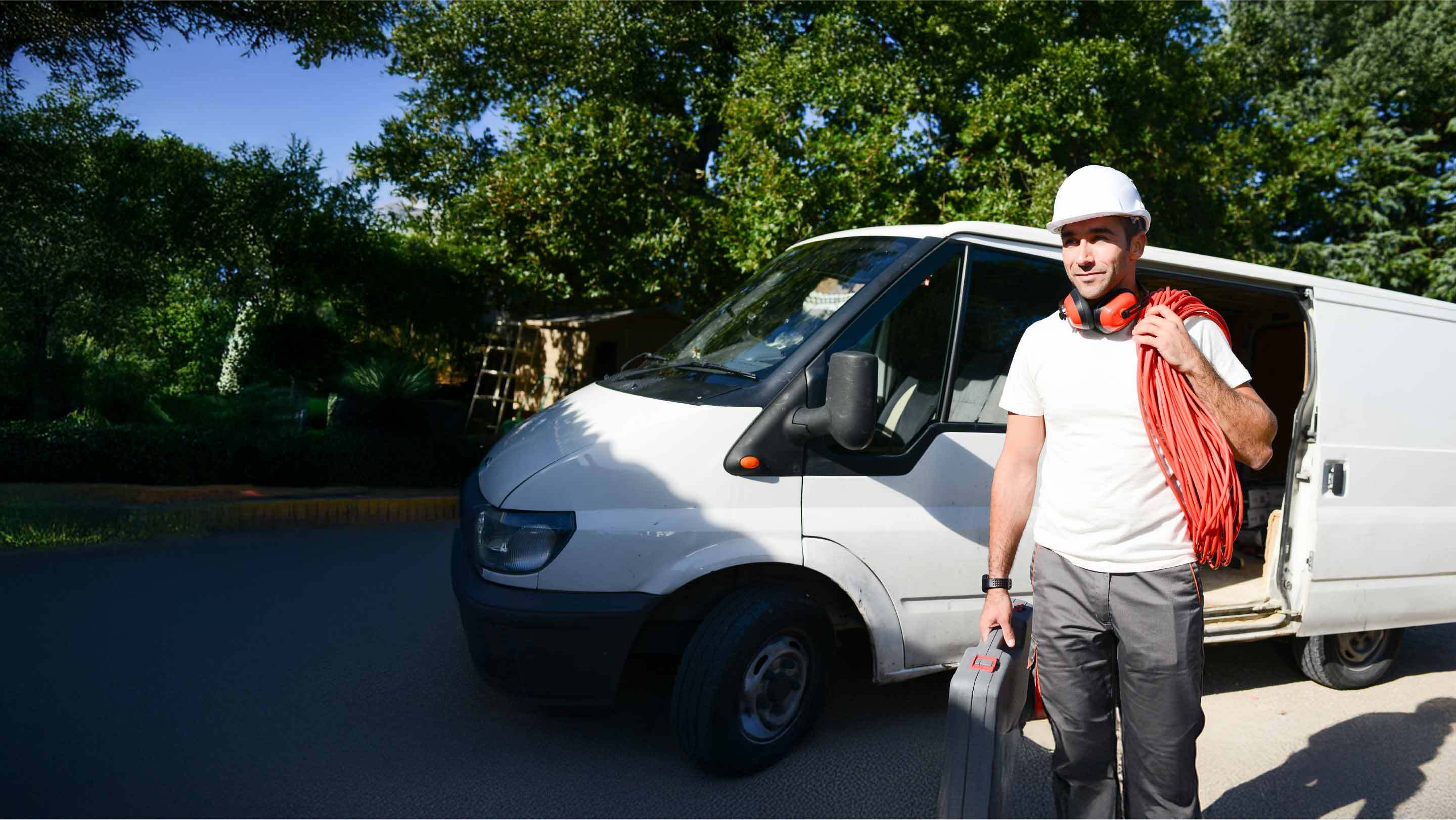 technician with red wires next to a white van
