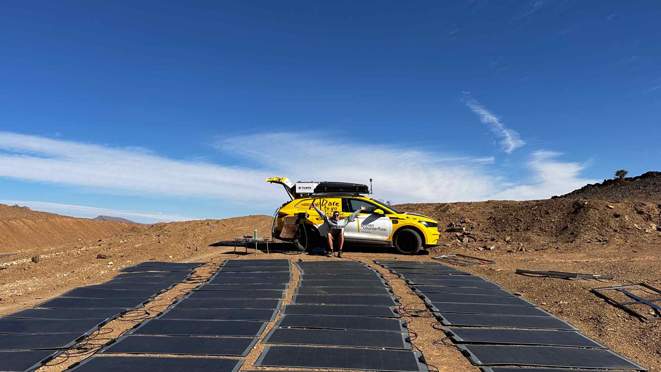 Ein Elektrofahrzeug der von einer Reihe von mobilen Solarpanelen aufgeladen wird.