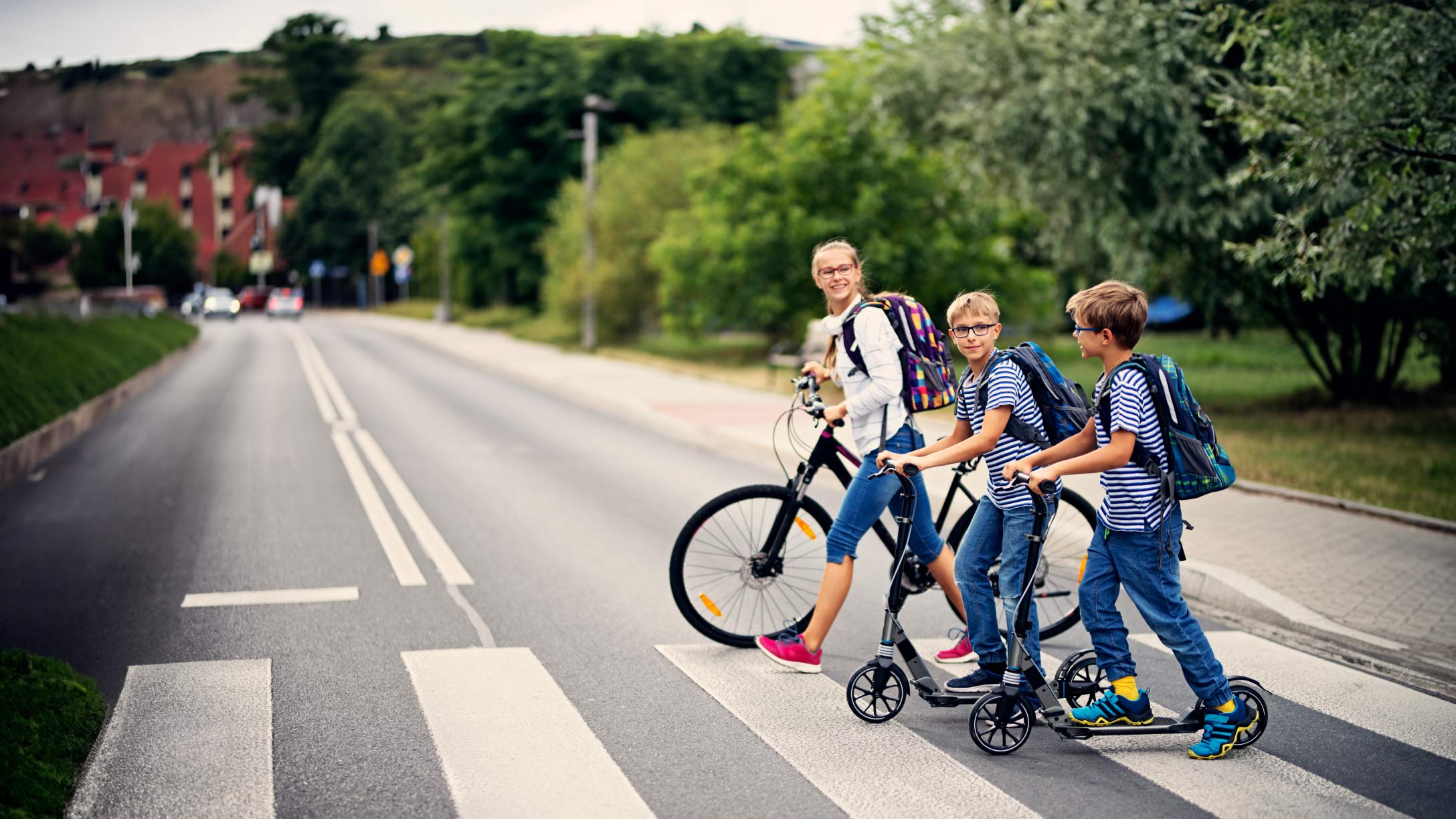 Teens with bicycles safely using the zebra croosing