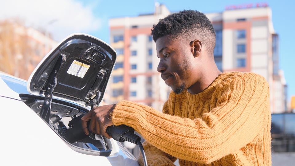 man charging electric vehicle