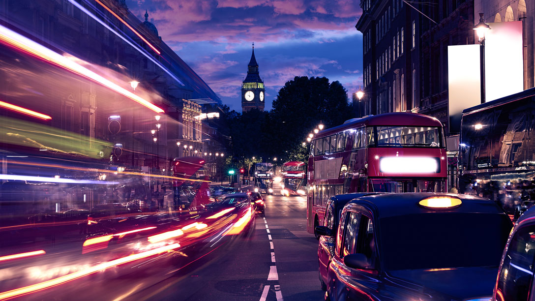 Vehicles driving on London street during night time 