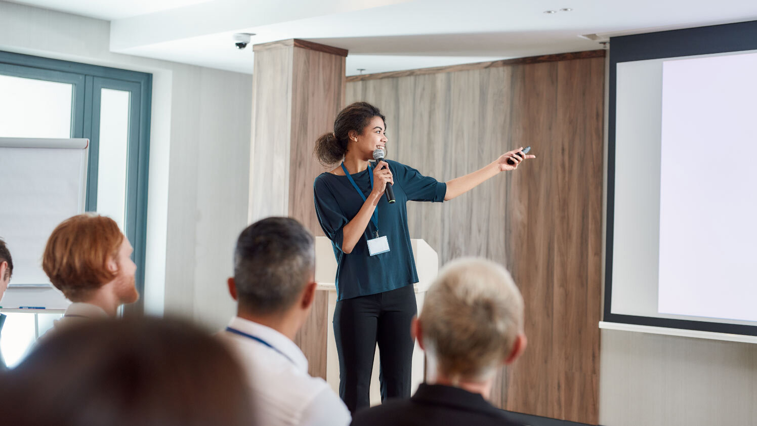 person gesturing at a projector screen