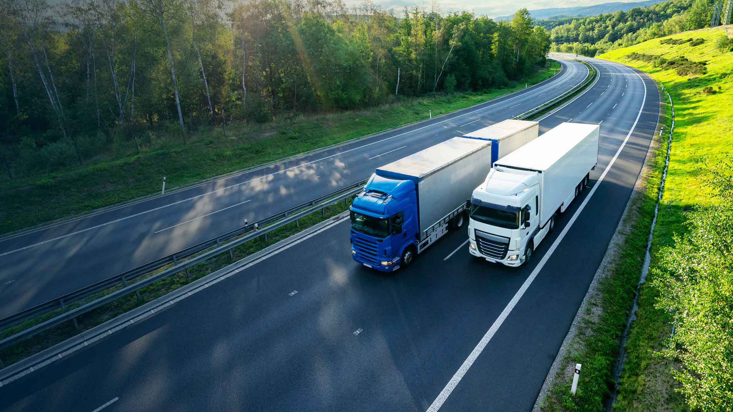 Vista aerea di un'autostrada con due grandi camion pesanti che viaggiano uno accanto all'altro