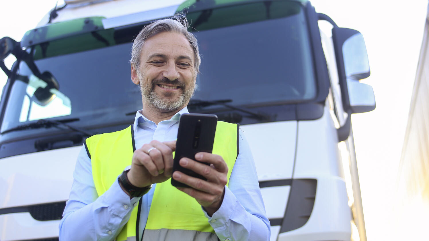 person standing next to a truck using a phone