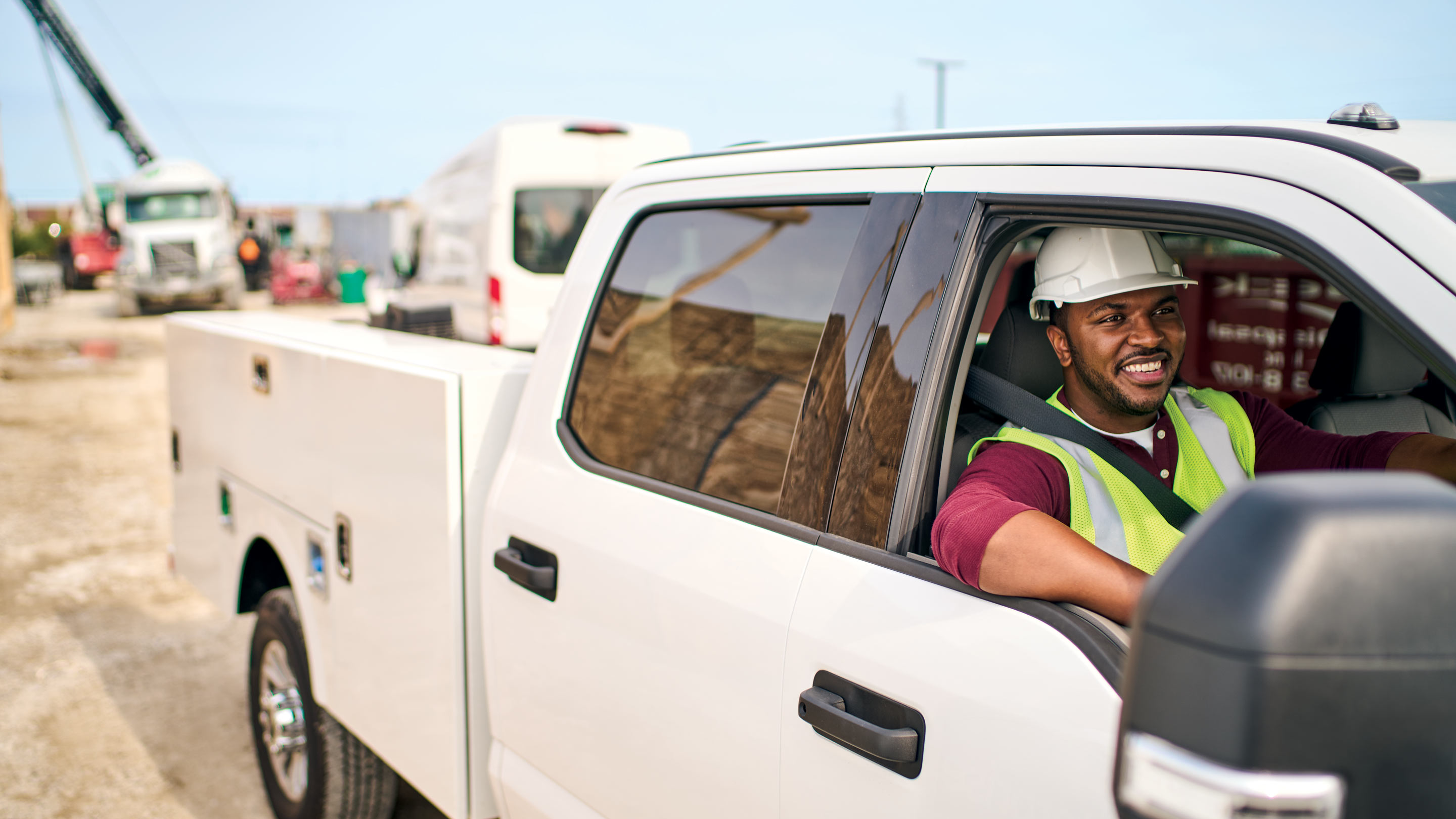 a construction worker driving and smiling