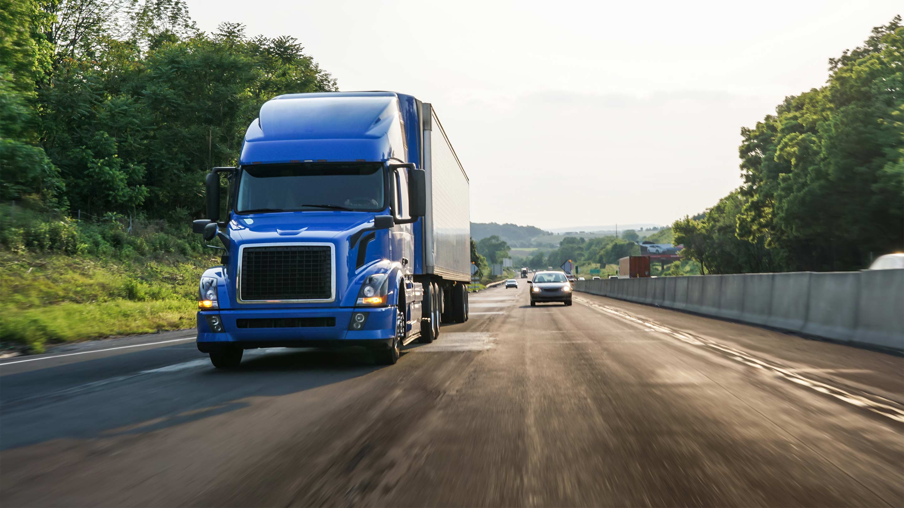 Heavy truck drivng next to car on two lane highway