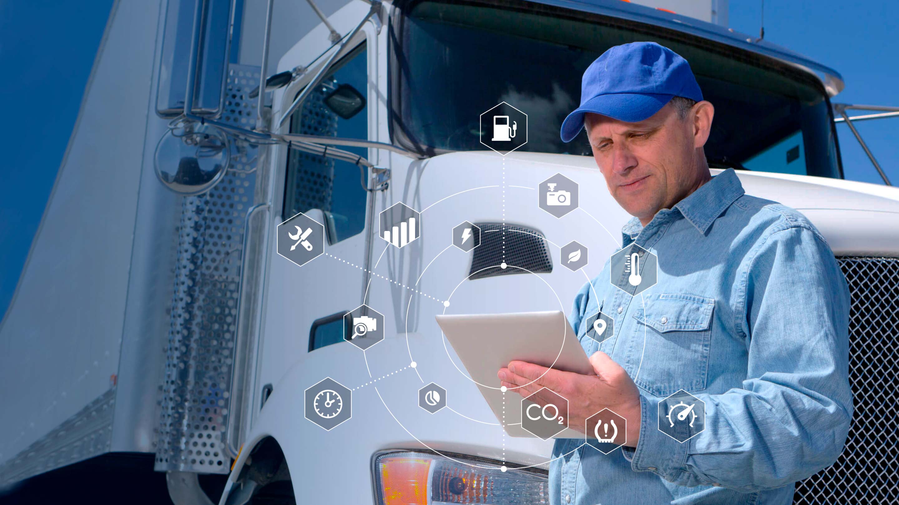 Man using tablet while standing in front of a white truck