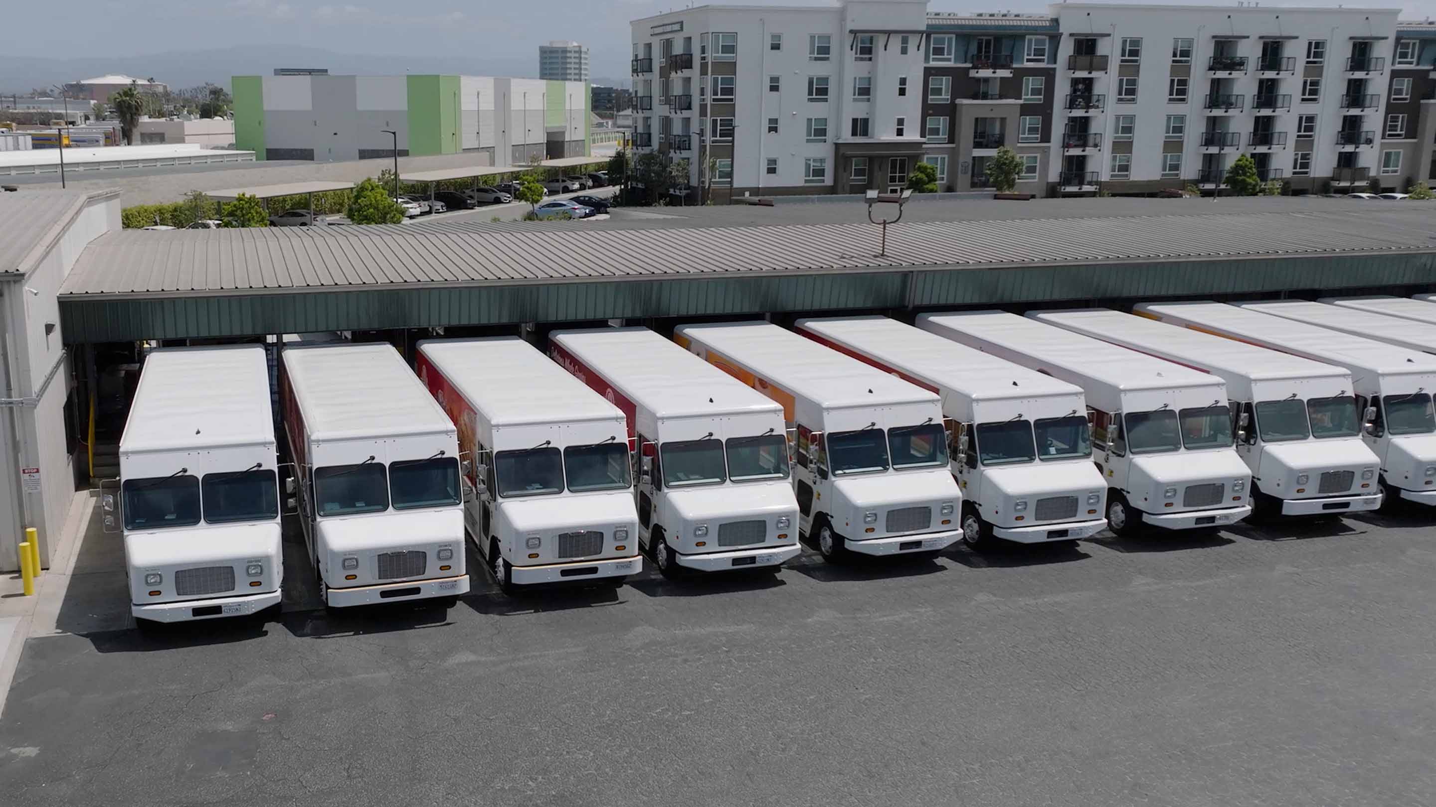 Line of motiv delivery trucks parked next to each other at warehouse