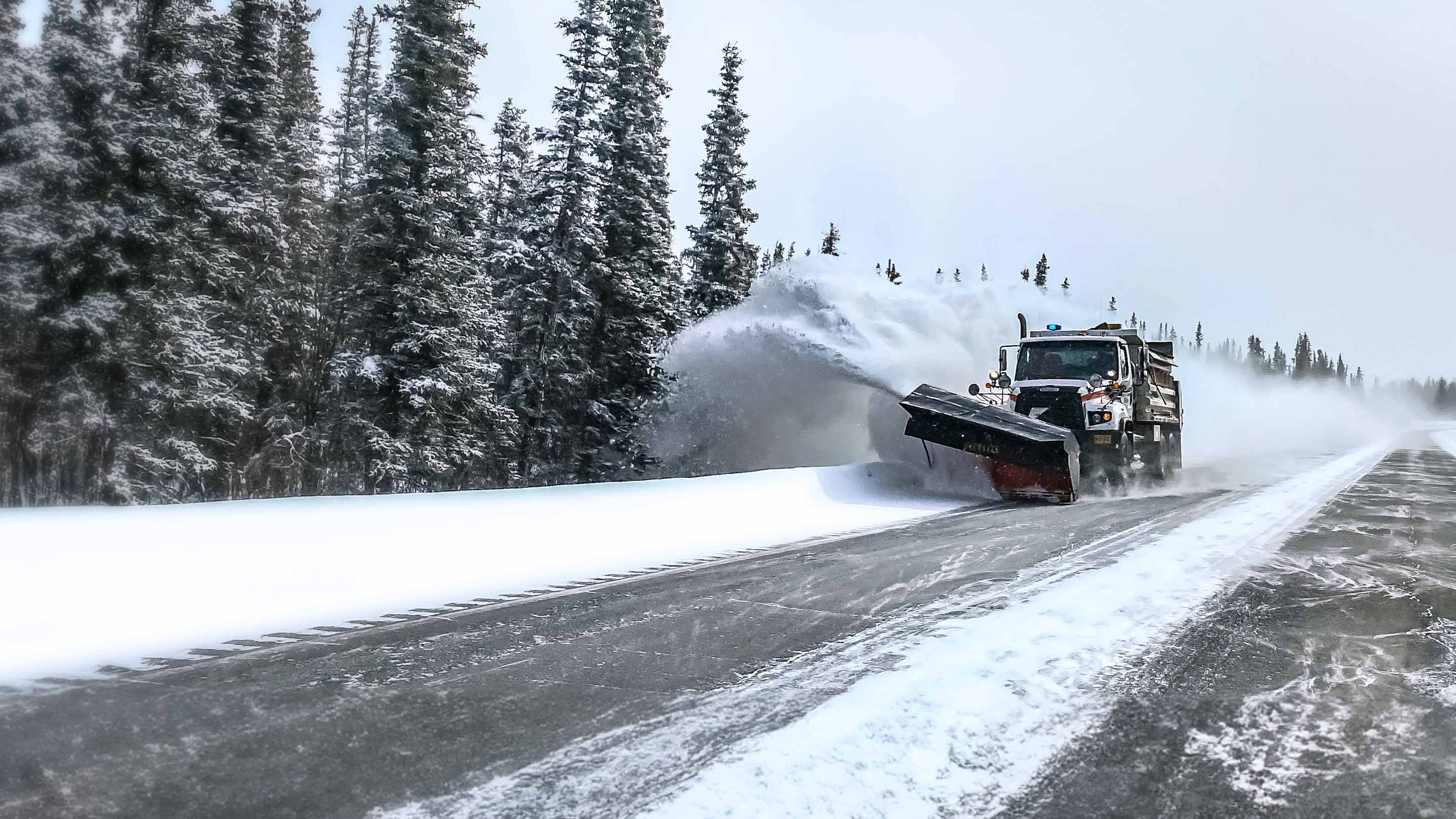 Snow plow removing snow from road