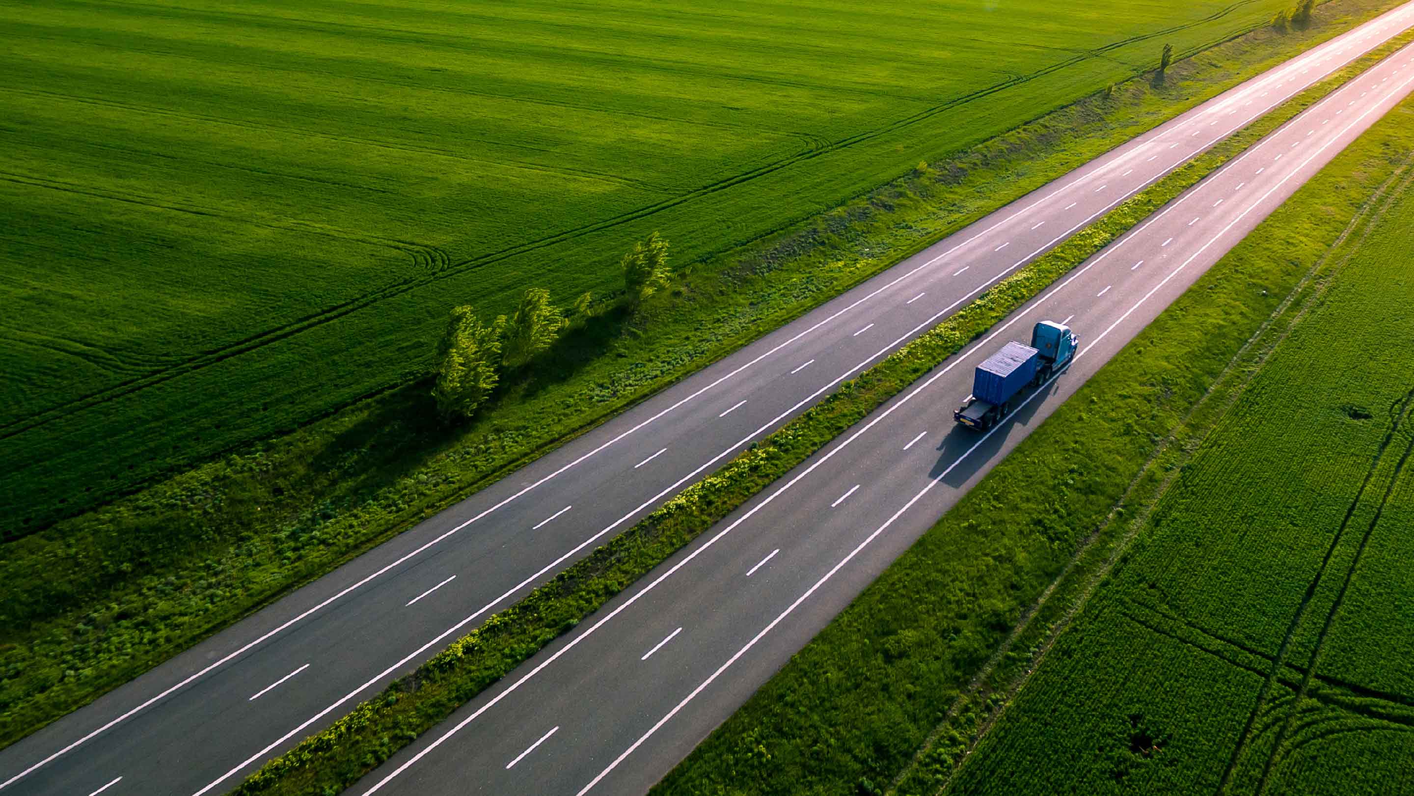 heavy truck driving down empty two lane highway