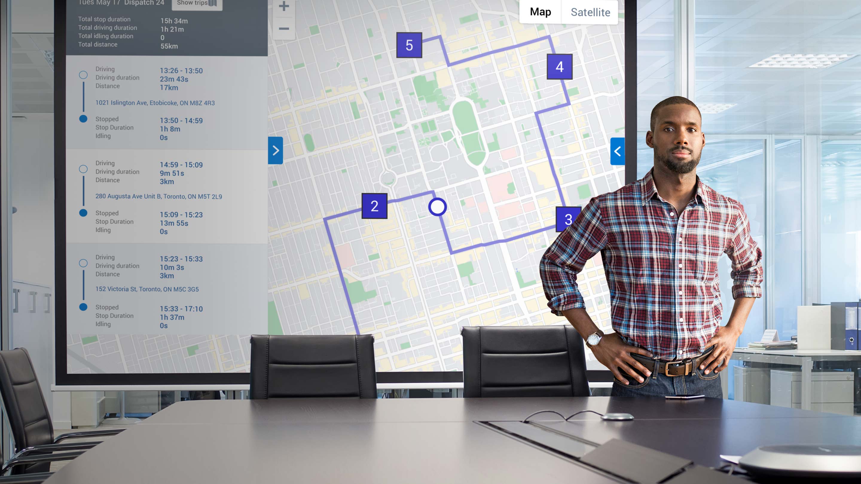 Man standing infront of large screen with mygeotab tracking UI