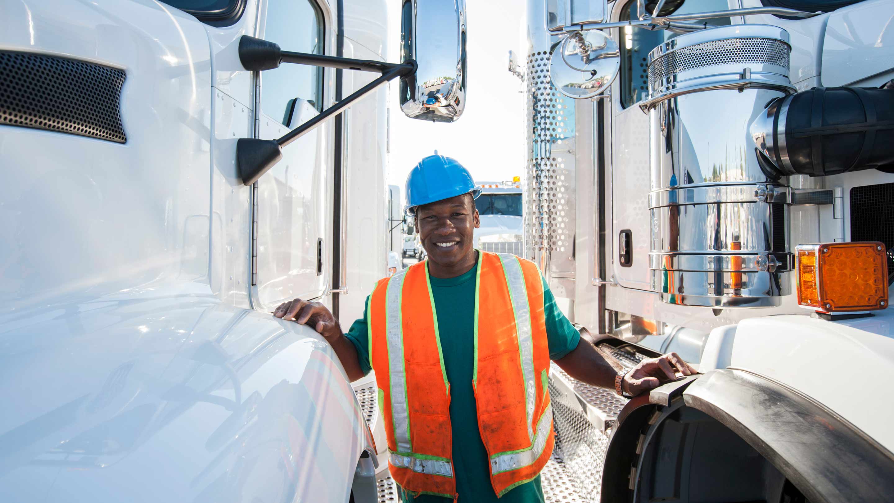 Worker standing between tow heavy trucks